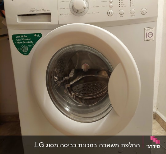 מכונת כביסה לבנה עם בגדים מעליה